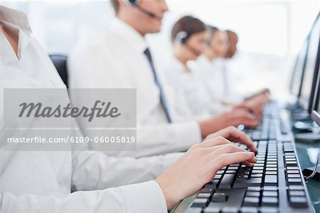Hands of call center agents working on keyboards