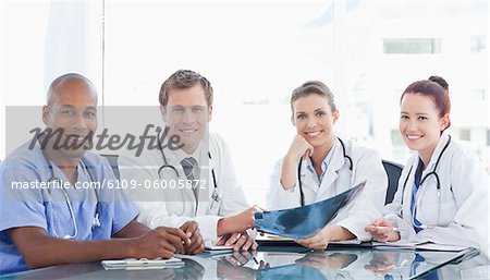 Lächelnd medizinischem Personal zusammen an einem Tisch sitzen
