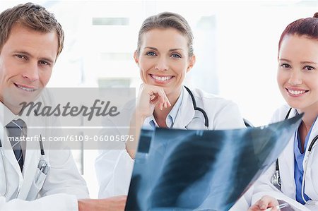 Trois médecins souriants avec une radiographie