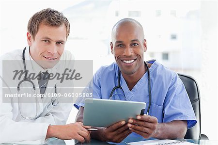 Two smiling doctors with tablet computer