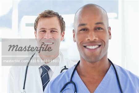 Smiling male doctors standing in a row