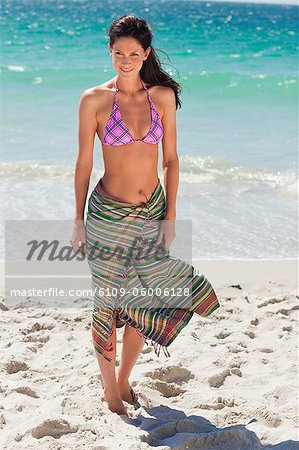 Attractive woman in bikini and sarong with sea in background