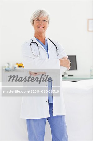 Smiling mature doctor with her arms crossed