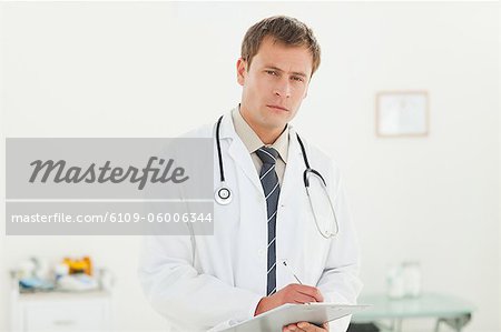 Young doctor with notepad in his examination room