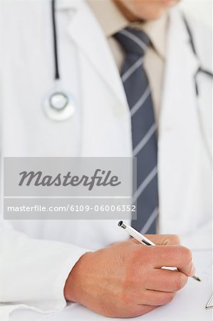Close up of prescription being filled by male doctor