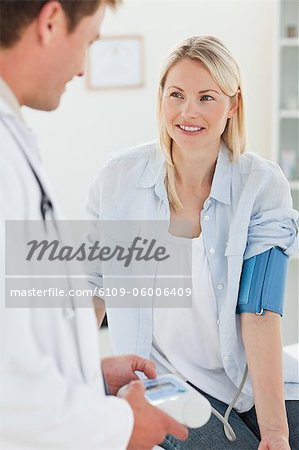 Smiling young woman getting her blood pressure measured