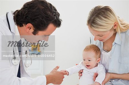Doigt de médecins masculins accaparement bébé
