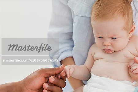 Male hand holding little babys hand