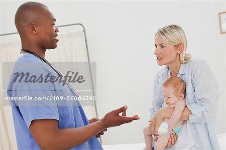 Side view of male pediatrician talking to a mother