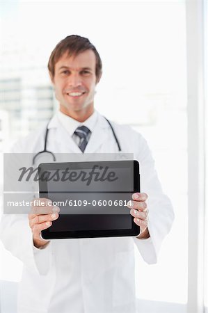 Tablet computer held by a smiling surgeon in front of a window