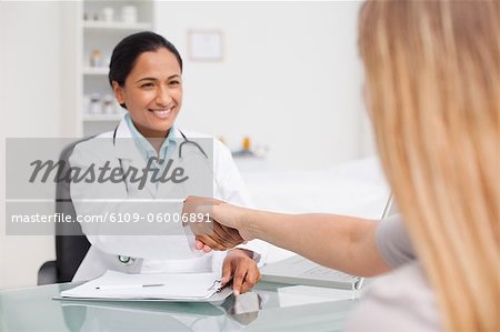 Handshake between a smiling doctor and her patient