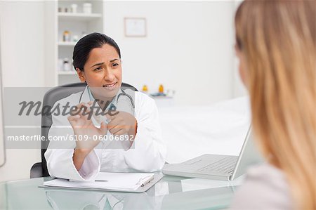 Serious doctor holding pills to give explanations to her patient