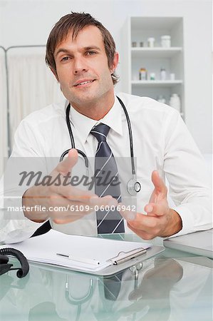 Relaxed doctor looking straight at the camera while giving some explanations