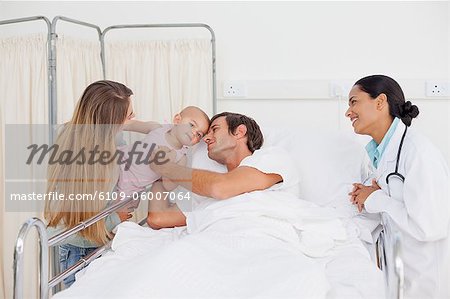 Patient Couche Dans Un Lit D Hopital Tout En Serrant Son Bebe Et Examinee Par Un Medecin Photographie De Stock Masterfile Premium Libres De Droits Code 6109