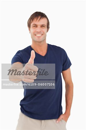 Thumb up a smiling man against a white background