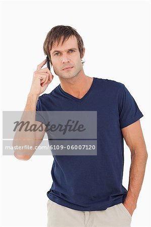 Serious man using his mobile phone while looking straight at the camera