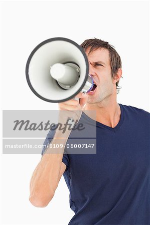 Wütenden Mann mit einem Megaphon während Geschrei vor einem weißen Hintergrund