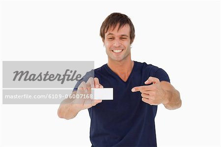 Leere Visitenkarte durch einen lächelnden Mann vor einem weißen Hintergrund gehalten