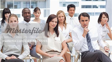 Serious colleagues looking ahead of them as they sit next to each other