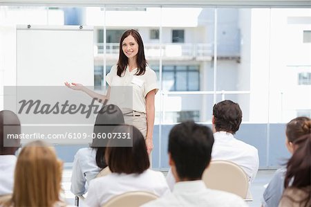 Souriant brunette femme d'affaires, faire une présentation à ses collègues lors de l'utilisation d'un graphique