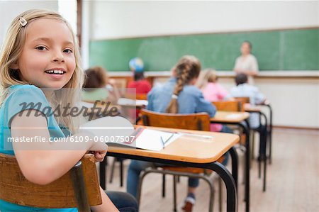 Smiling elementary student turning around during class