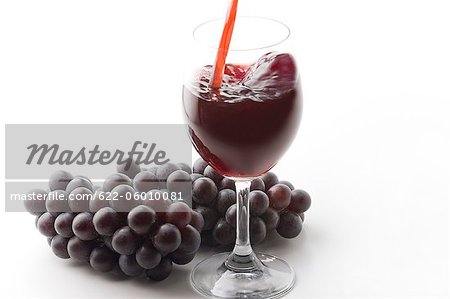 Grapes Juice Filling In Drinking Glass Beside Grapes