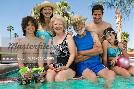 Fille (10-12) avec le frère (13-15), les parents et grands-parents à la piscine, portrait.