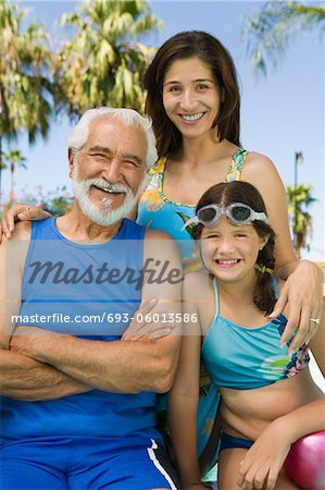 Girl (10-12) with mother and grandfather, front view portrait.