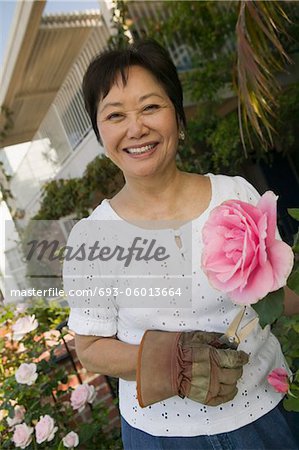 Femme avec une rose rose, outdoors, (portrait)