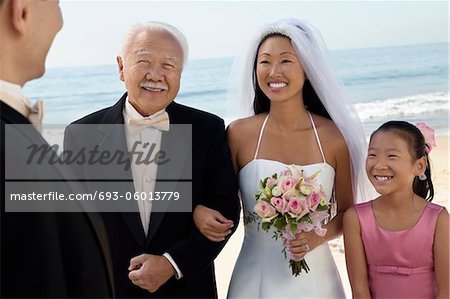 Mariée et le marié avec une famille à l'océan