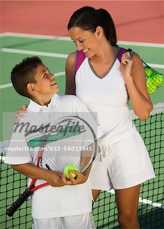 Mère et fils de filet sur le court de tennis, vue grand angle