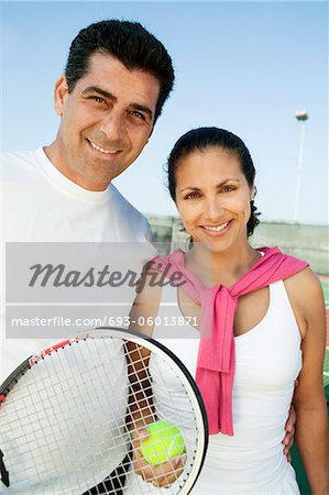 Mixed doubles Tennis Players standing on tennis court, portrait