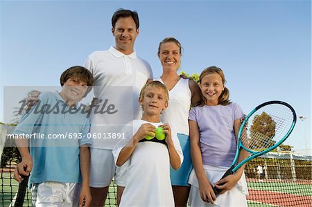 Famille sur tennis par net, portrait, vue de face