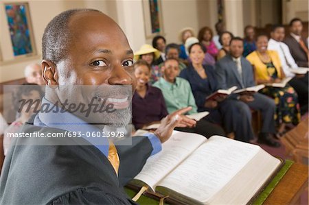 Preacher at altar with Bible preaching to Congregation, portrait, close up