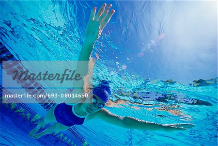 Woman swimming floating underwater, (low angle view)