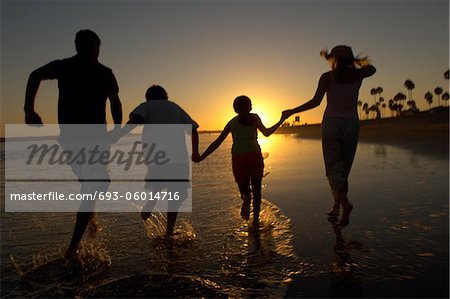 Familie ausgeführt durch Meer Hand in Hand bei Sonnenuntergang, hintere Ansicht, Kontur