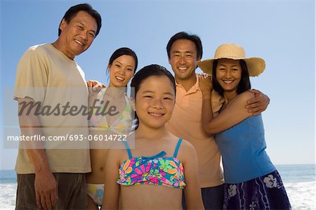 Famille avec la fille (7-9) sur la plage, (portrait)