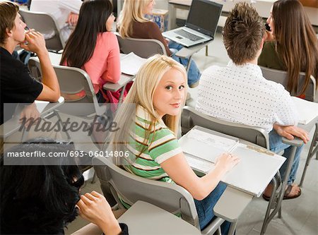 Student sitting at desk during class, (portrait)