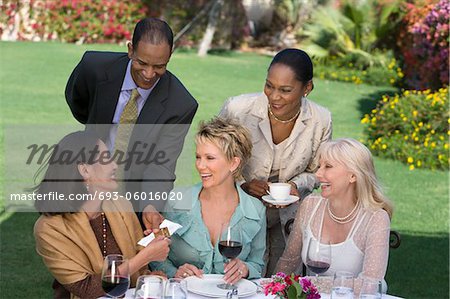 Woman receiving present from friends outdoors