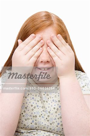Portrait d'une jeune adolescente qui couvre les yeux avec les mains