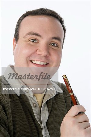 Portrait of mid-adult man holding pen, smiling