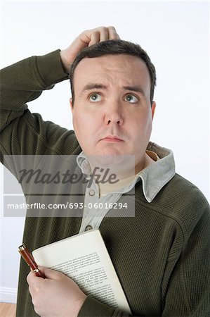 Portrait d'homme Mid tenant plume et livre, grattant la tête