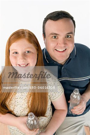 Portrait du père et fille tenant des bouteilles