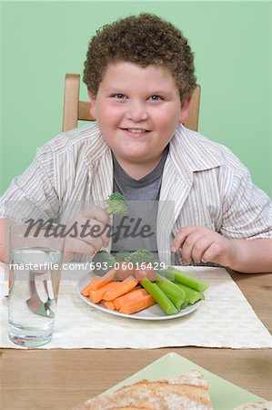 Overweight boy having healthy meal.