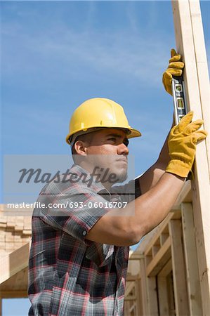 Bauarbeiter mit Wasserwaage auf Gebäude