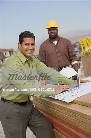 Construction worker using laptop, portrait