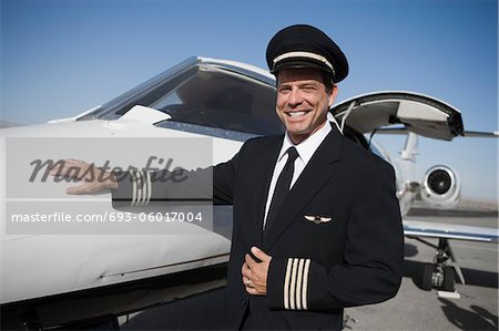 Portrait of pilot standing in front of airplane.
