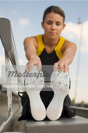 Female track athlete stretching