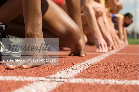 Gruppe von weiblichen Track Athleten auf Startblöcke