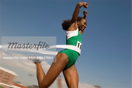 Female track athlete crossing finishing line